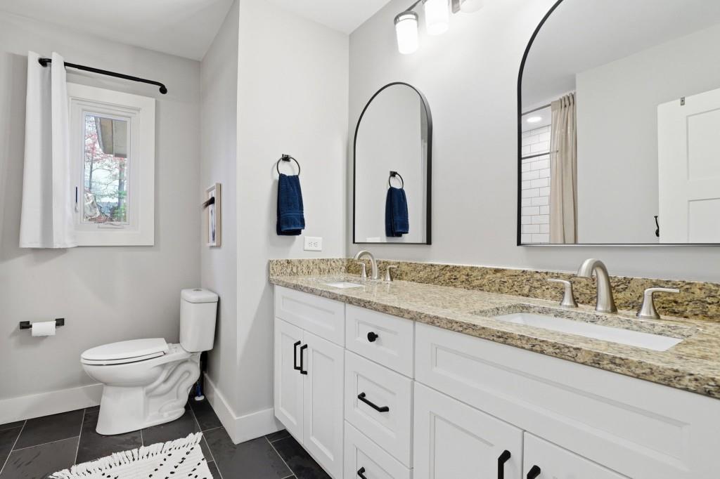 864 Stratford Road Avondale Estates, GA 30002 - Photo 23 of 54 a bathroom with a granite countertop toilet sink and mirror