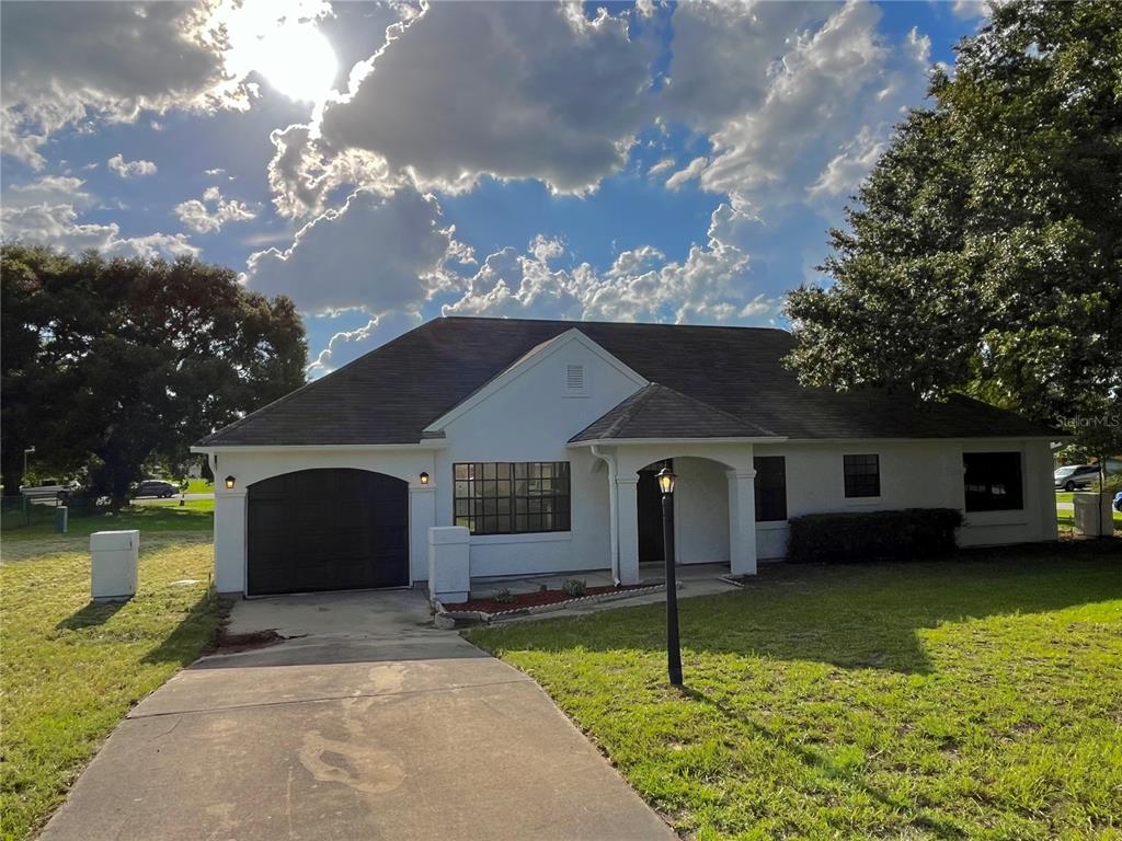 301 Oak Track Way Ocala, FL 34472 - Photo 1 of 1 a front view of a house with a garden and trees