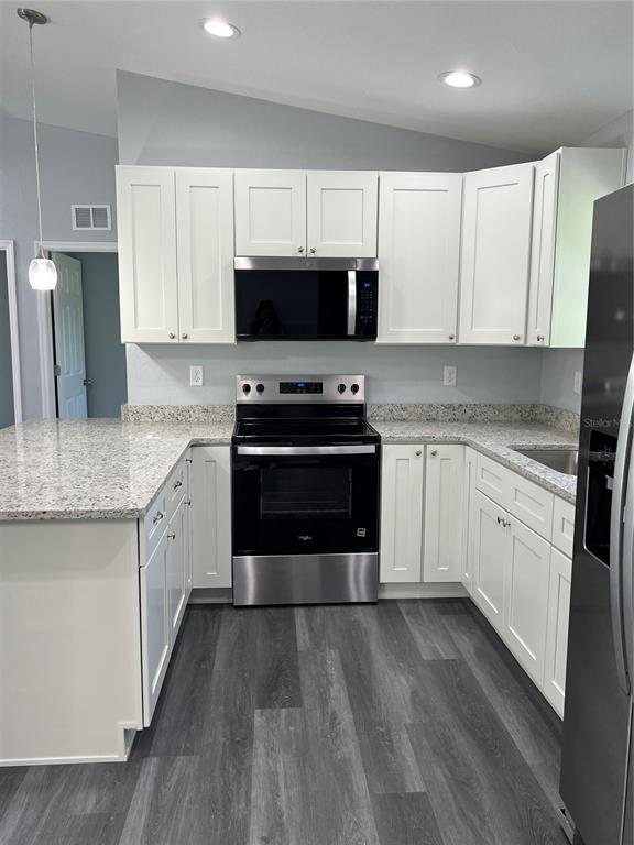 21260 Southwest Marine Boulevard Dunnellon, FL 34431 - Photo 2 of 13 a kitchen with stainless steel appliances granite countertop a stove top oven a sink dishwasher and a refrigerator with wooden floor