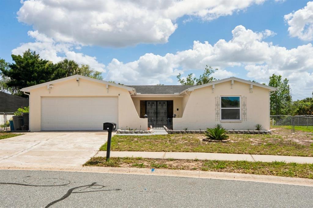 6955 Bottle Brush Drive Port Richey, FL 34668 - Photo 1 of 61 a house with trees in front of it