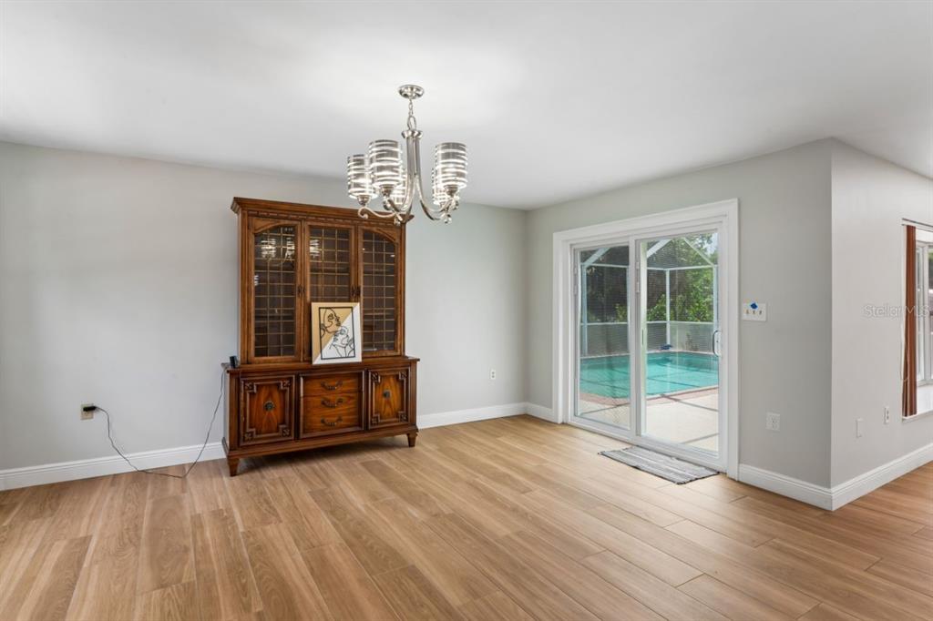 6955 Bottle Brush Drive Port Richey, FL 34668 - Photo 18 of 61 a view of an empty room with wooden floor and a window