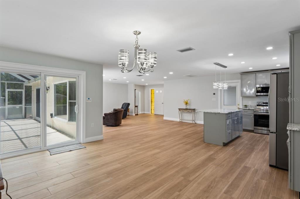 6955 Bottle Brush Drive Port Richey, FL 34668 - Photo 20 of 61 a large room with kitchen view and living room view