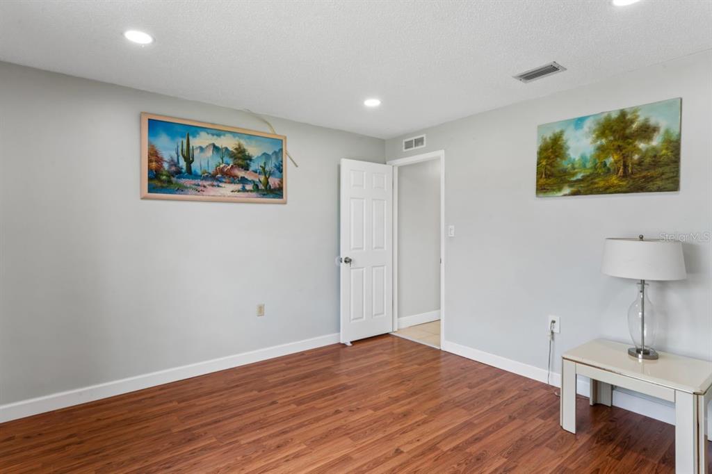 6955 Bottle Brush Drive Port Richey, FL 34668 - Photo 30 of 61 a view of an empty room with wooden floor and a lamp