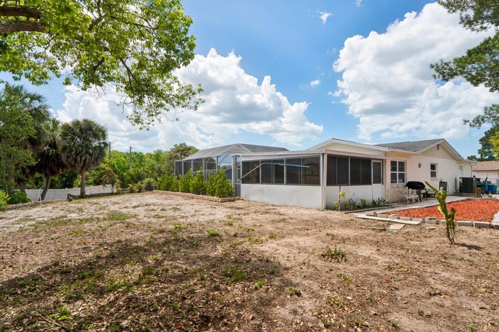6955 Bottle Brush Drive Port Richey, FL 34668 - Photo 47 of 61 a front view of a house with a yard