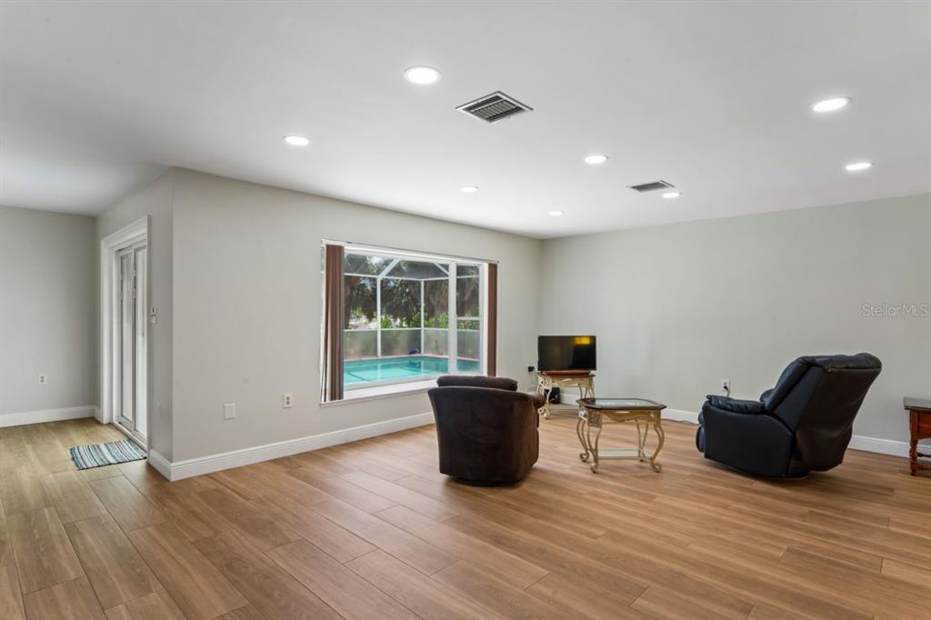 6955 Bottle Brush Drive Port Richey, FL 34668 - Photo 8 of 61 a living room with furniture and a flat screen tv