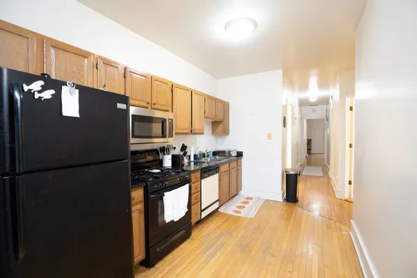 a kitchen with stainless steel appliances granite countertop a refrigerator a stove and a sink