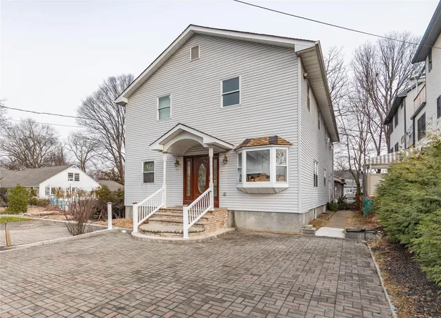 a view of a white house with a yard covered in snow