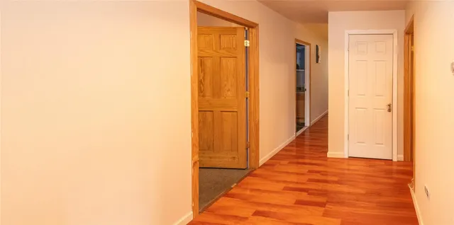 a view of a hallway with wooden floor and entryway