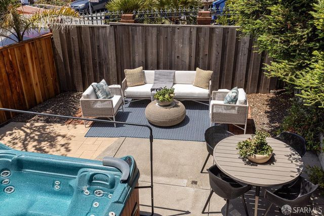a view of a patio with couches table and chairs and potted plants