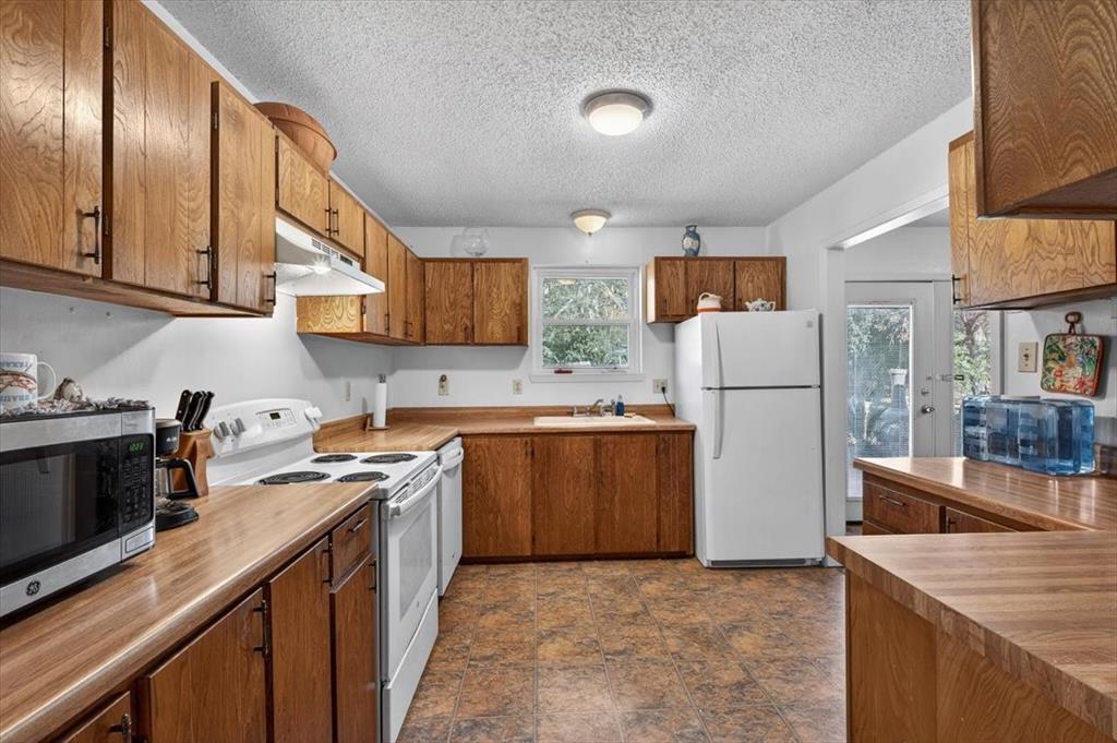 1706 Hitching Post Road Granbury, TX 76049 - Photo 14 of 40 a kitchen with a sink a stove and a refrigerator
