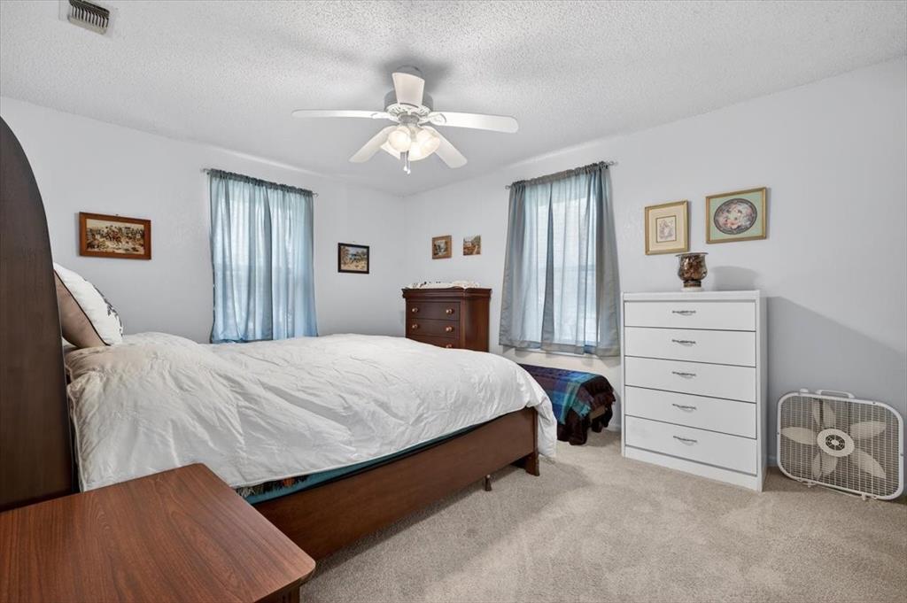 1706 Hitching Post Road Granbury, TX 76049 - Photo 17 of 40 a bedroom with a bed and a chandelier