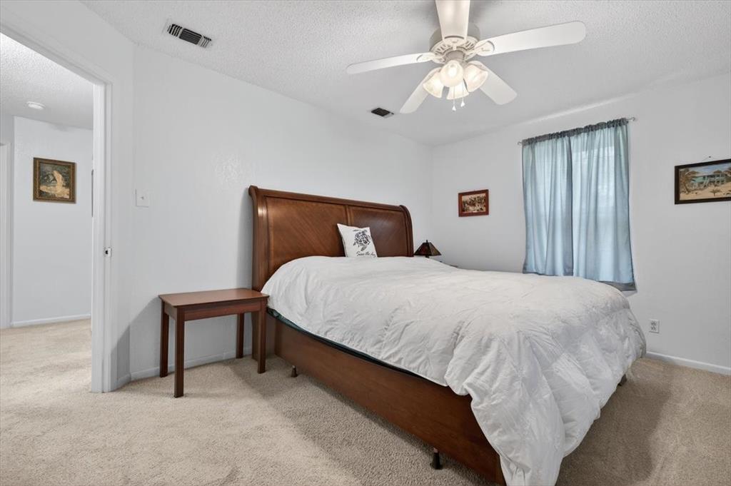 1706 Hitching Post Road Granbury, TX 76049 - Photo 18 of 40 a bedroom with a bed and a chandelier