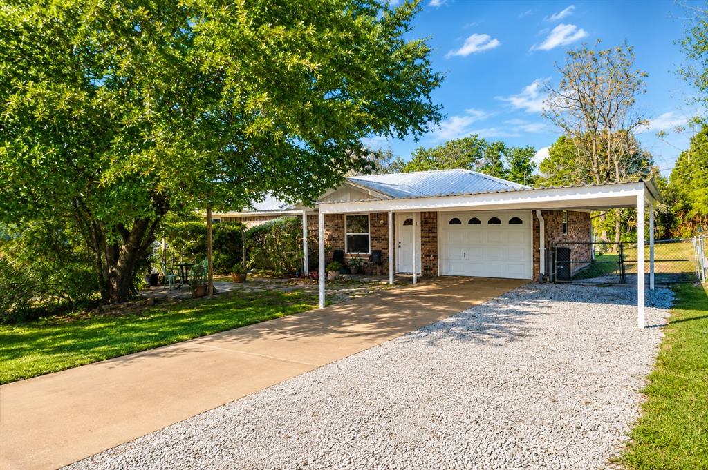 1706 Hitching Post Road Granbury, TX 76049 - Photo 2 of 40 a view of a house with a yard and tree s