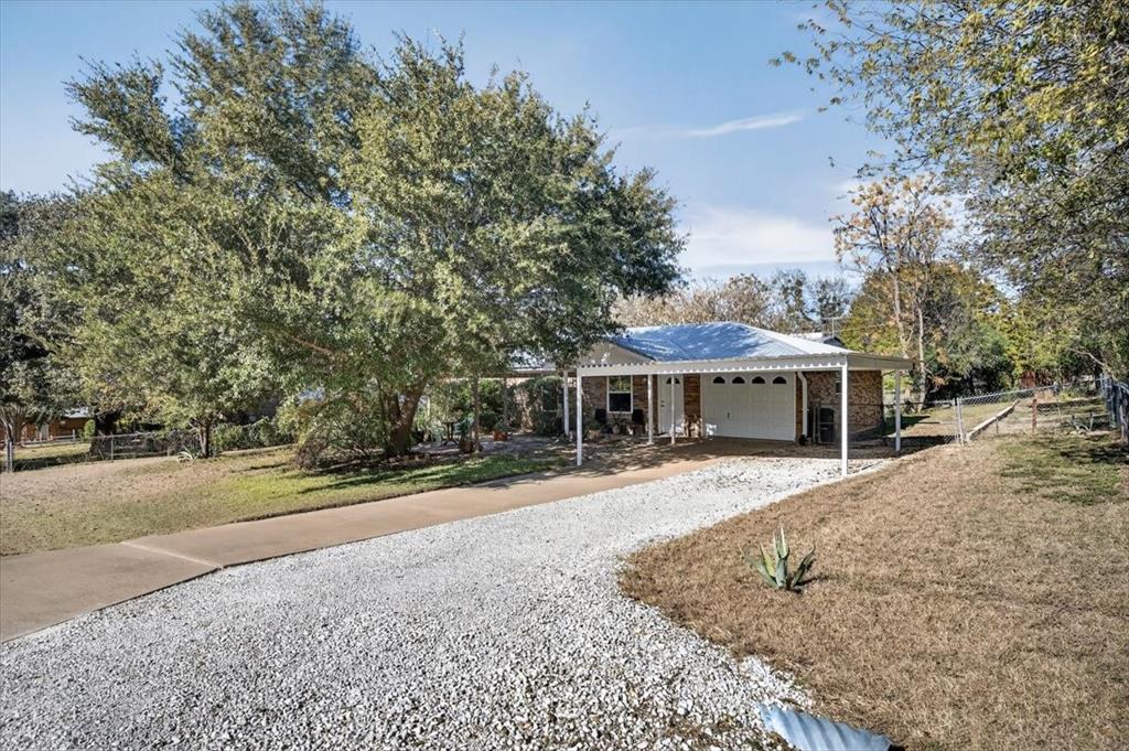 1706 Hitching Post Road Granbury, TX 76049 - Photo 36 of 40 a view of a house with backyard and trees