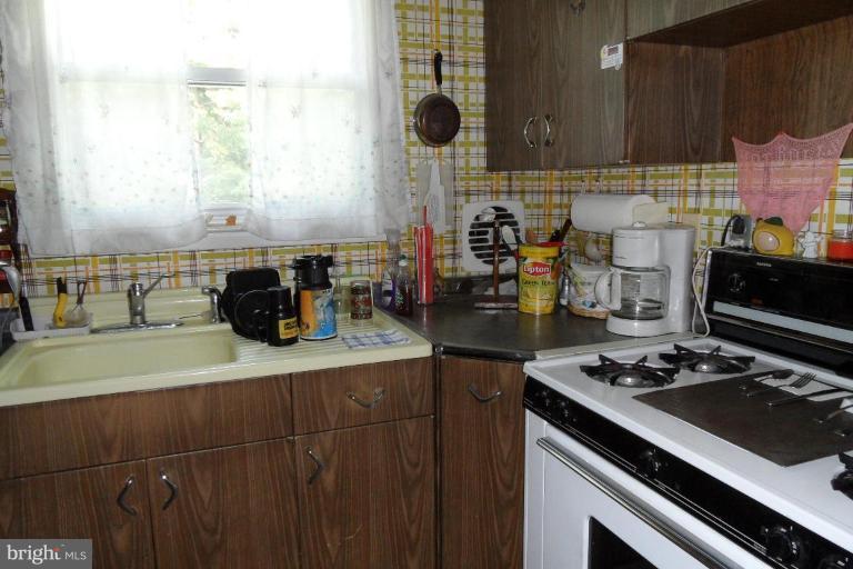 304 Charles Road Linthicum, MD 21090 - Photo 6 of 11 a kitchen with stainless steel appliances a stove a sink and a microwave