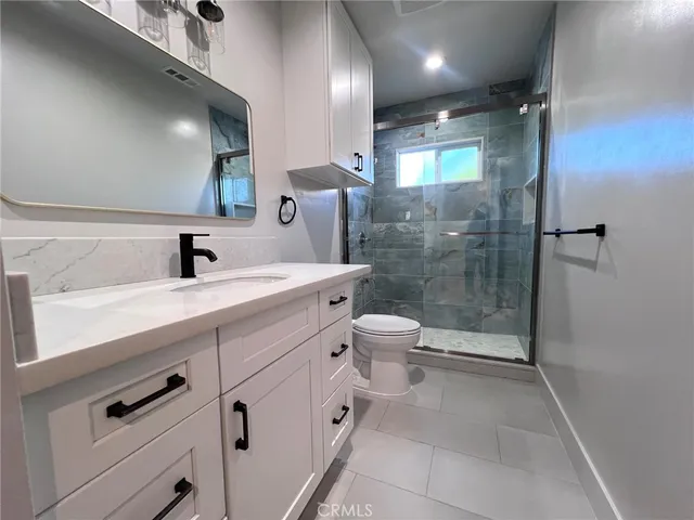 a bathroom with a double vanity sink toilet and shower