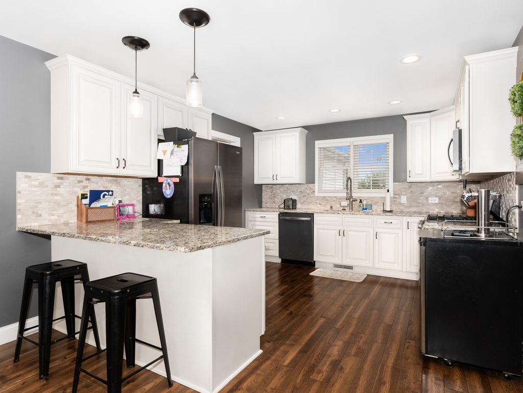 3964 East 2259th Road Serena, IL 60549 - Photo 12 of 36 a kitchen with kitchen island granite countertop wooden floors and white appliances