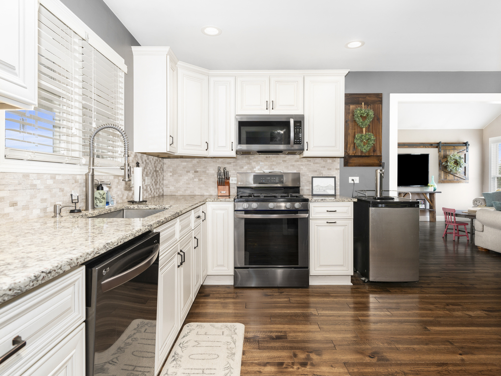 3964 East 2259th Road Serena, IL 60549 - Photo 14 of 36 a kitchen with stainless steel appliances granite countertop a stove top oven a sink dishwasher and a refrigerator with wooden floor