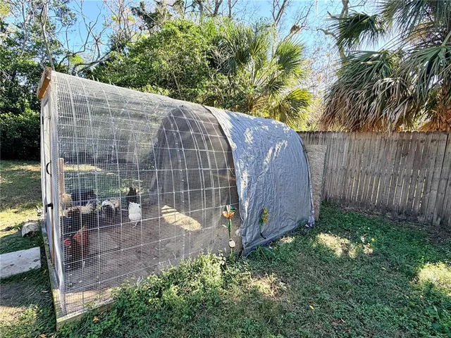 a view of a backyard with plants and a bench