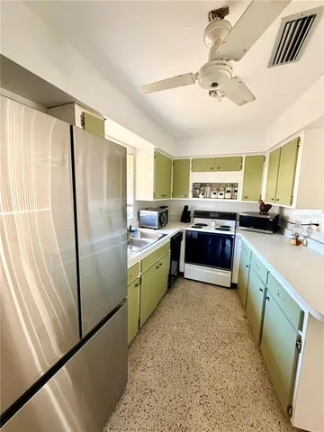 a kitchen with stainless steel appliances granite countertop a refrigerator a sink dishwasher a stove and a dining table with wooden floor