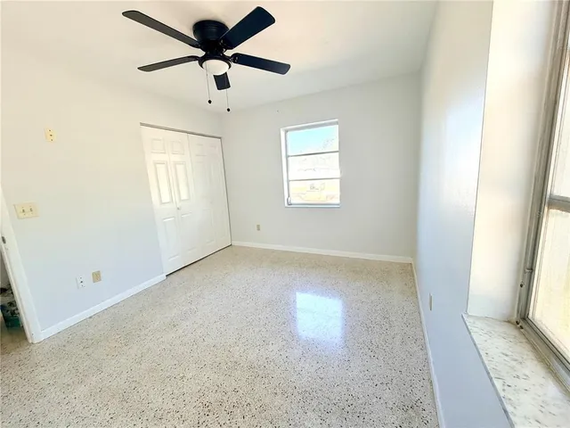 a view of a room with a ceiling fan and window
