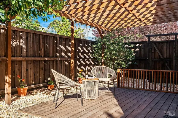 a view of a patio with table and chairs potted plants and large tree