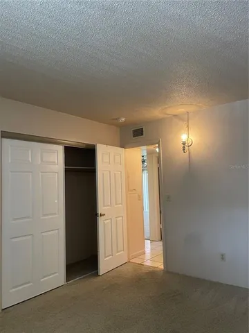 an empty room with closet and wooden door