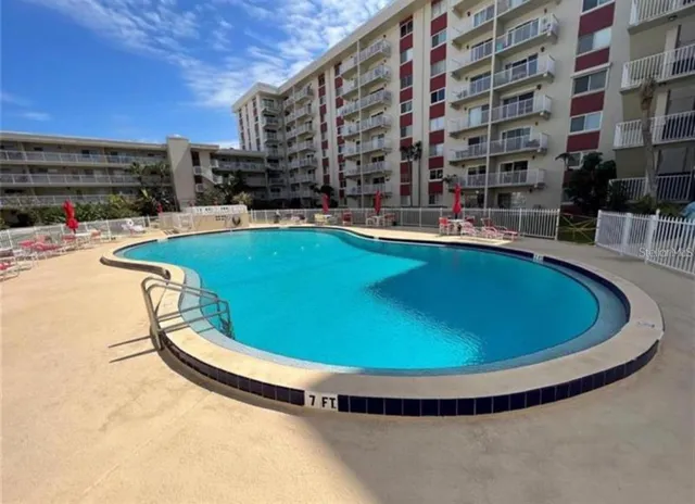 a view of a swimming pool with a bench and chairs