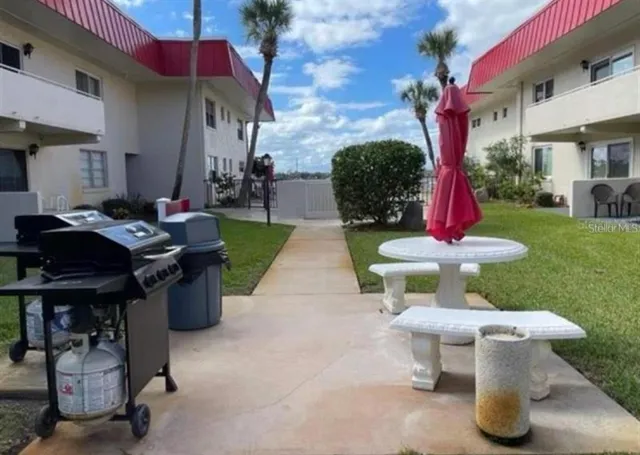 a view of a chair and table in backyard of the house
