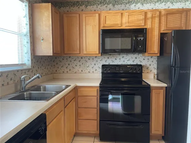 a kitchen with granite countertop a stove and a microwave
