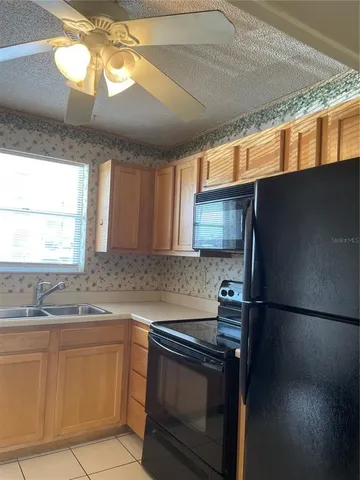 a kitchen with granite countertop stainless steel appliances a sink stove and a window