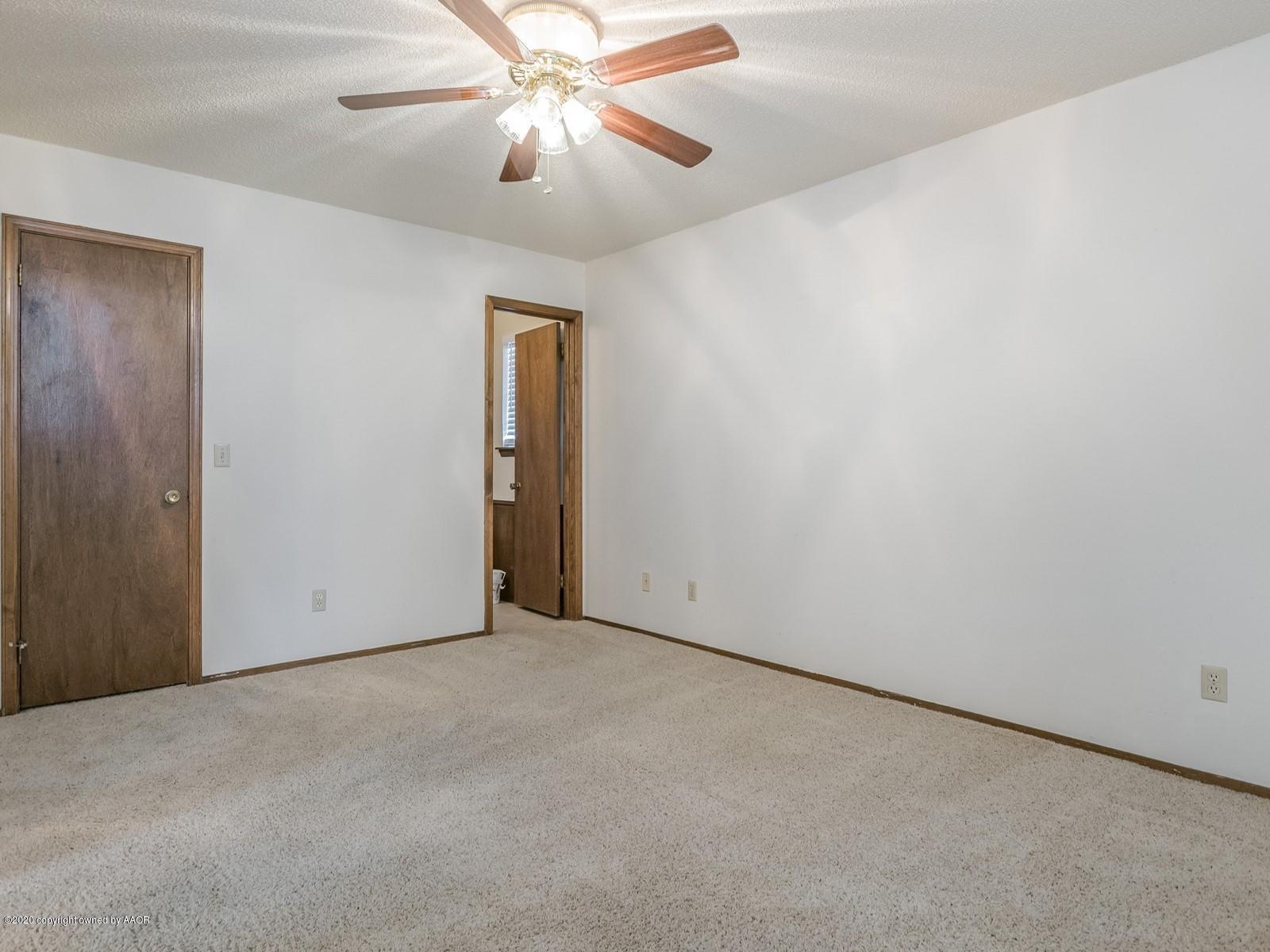 5301 South Milam Street Amarillo, TX 79110 - Photo 12 of 21 an empty room with a chandelier fan and closet area
