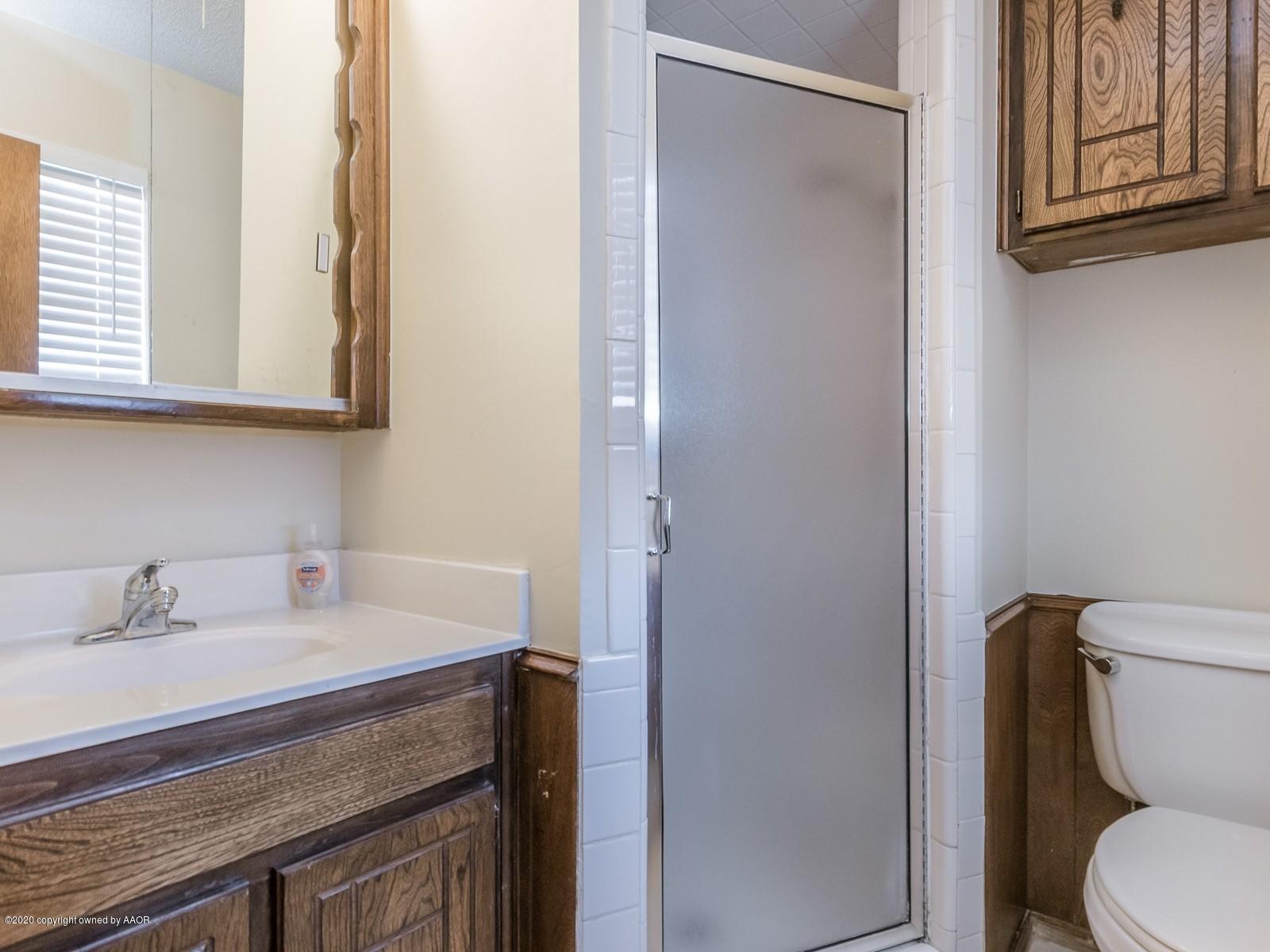 5301 South Milam Street Amarillo, TX 79110 - Photo 13 of 21 a bathroom with a granite countertop toilet sink and mirror