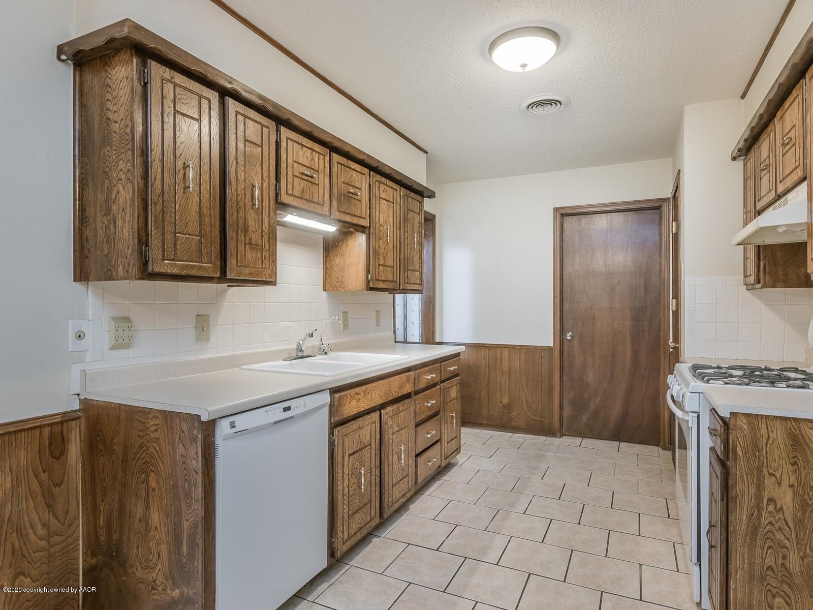 5301 South Milam Street Amarillo, TX 79110 - Photo 7 of 21 a kitchen with a sink stove and cabinets