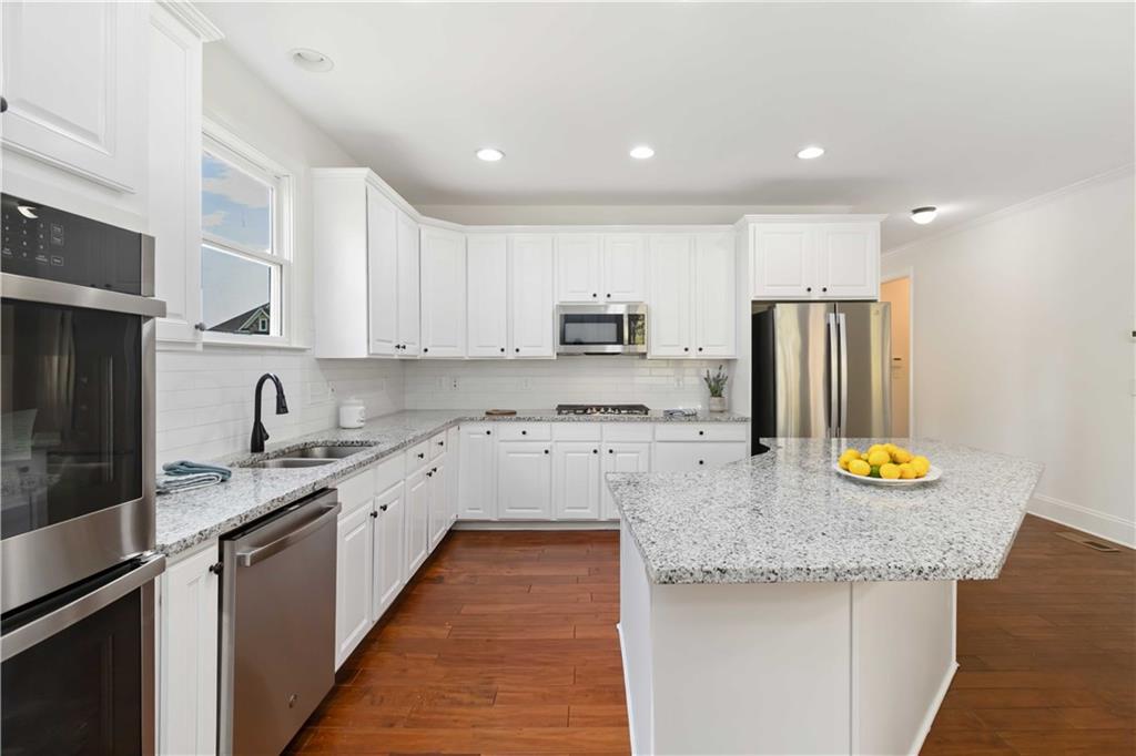 3320 Spencer Street Cumming, GA 30041 - Photo 15 of 70 a kitchen with stainless steel appliances granite countertop a sink stove and refrigerator