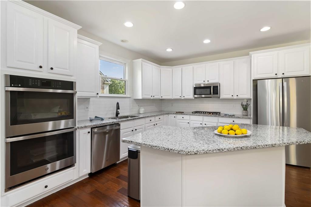3320 Spencer Street Cumming, GA 30041 - Photo 16 of 70 a kitchen with stainless steel appliances granite countertop a sink stove and refrigerator