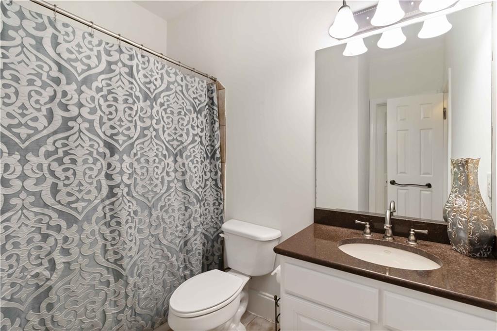 3320 Spencer Street Cumming, GA 30041 - Photo 17 of 70 a bathroom with a granite countertop sink mirror vanity and toilet