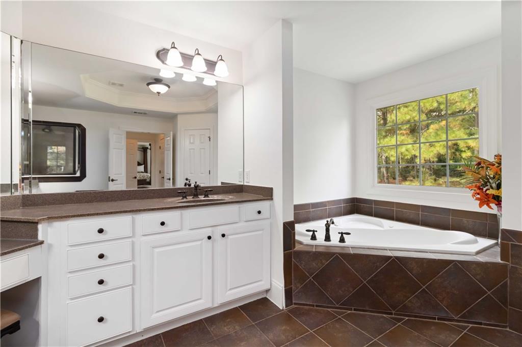 3320 Spencer Street Cumming, GA 30041 - Photo 36 of 70 a spacious bathroom with a tub a double vanity sink and a window