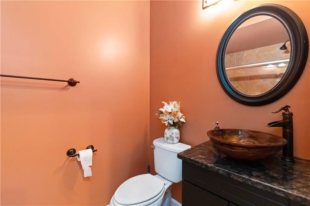 3320 Spencer Street Cumming, GA 30041 - Photo 44 of 70 a bathroom with a granite countertop toilet a sink and mirror
