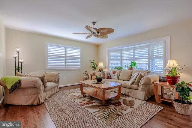 a large kitchen with cabinets a sink dishwasher a dining table and chairs with wooden floor