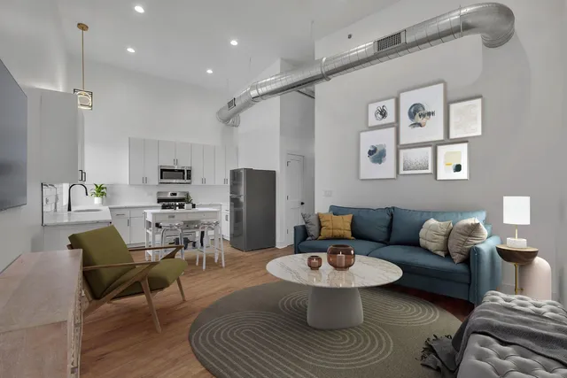 a living room with furniture a rug and kitchen view