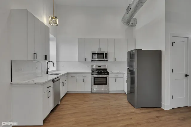 a kitchen with stainless steel appliances granite countertop a refrigerator sink and stove