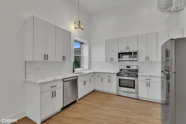 a kitchen with white cabinets and stainless steel appliances