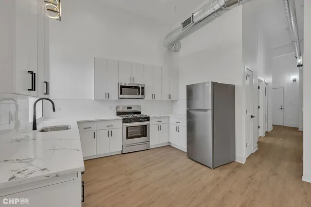 a kitchen with stainless steel appliances a refrigerator sink and cabinets