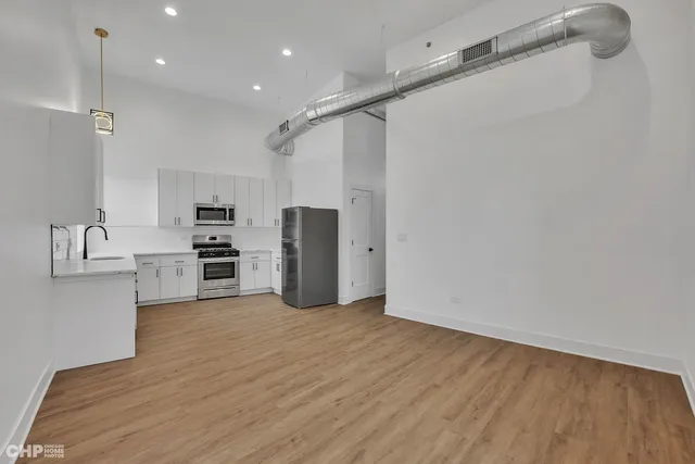 a view of kitchen with refrigerator microwave and stove top oven