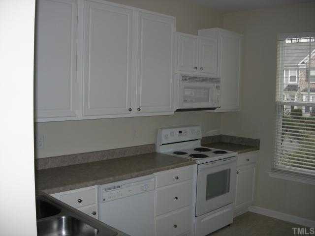 8453 Central Drive Raleigh, NC 27613 - Photo 2 of 8 a kitchen with granite countertop white cabinets and white appliances