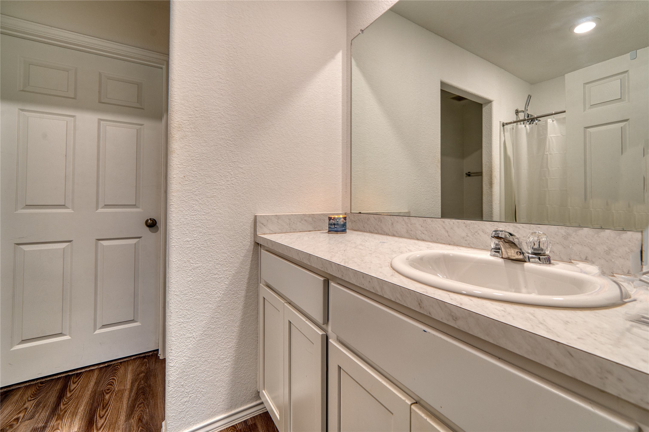 184 Kelly Street Angleton, TX 77515 - Photo 10 of 19 The primary bathroom features a crisp, neutral design with ample counter space and bright lighting. The clean white cabinetry and classic fixtures create a timeless, move-in-ready feel for your daily routine.
