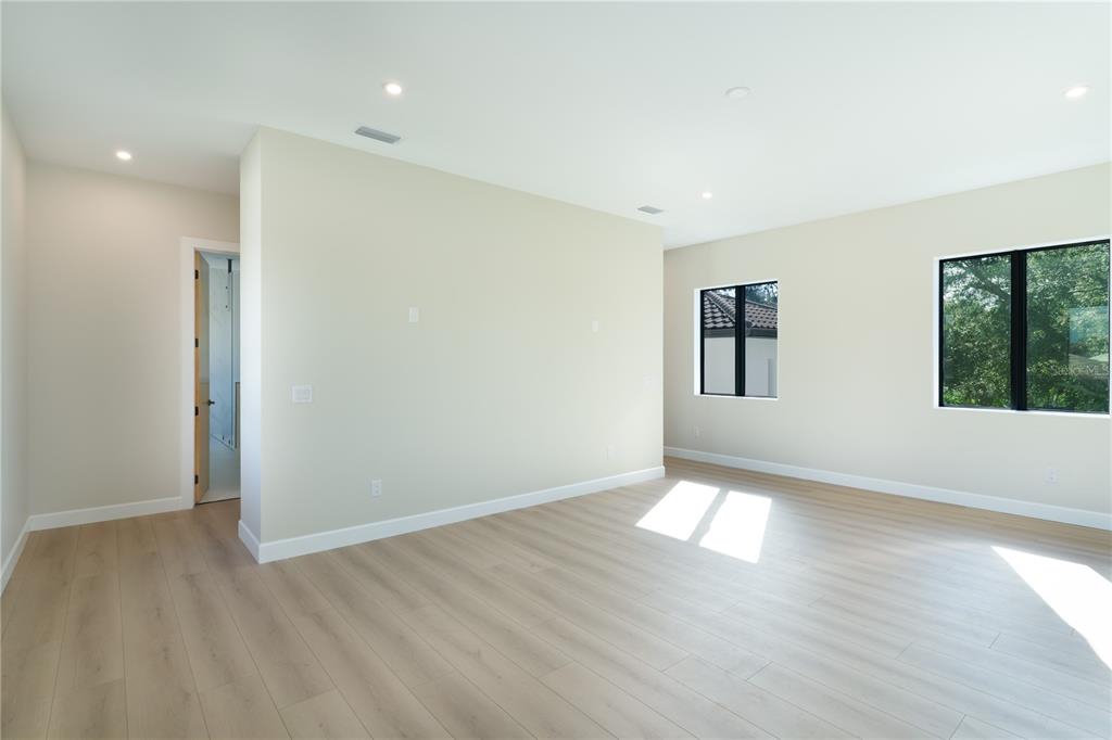 2414 Bayshore Road Nokomis, FL 34275 - Photo 20 of 64 a view of an empty room with wooden floor and windows
