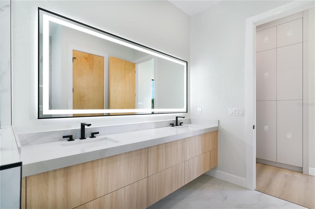 2414 Bayshore Road Nokomis, FL 34275 - Photo 25 of 64 a bathroom with a double vanity sink and mirror