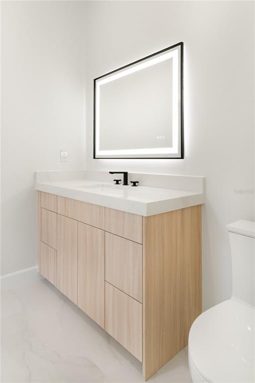 2414 Bayshore Road Nokomis, FL 34275 - Photo 35 of 64 a bathroom with a sink a toilet and mirror